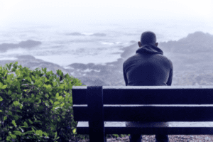 "Depressed man sitting alone on a bench, symbolizing the emotional struggles addressed through counselling and therapy."
